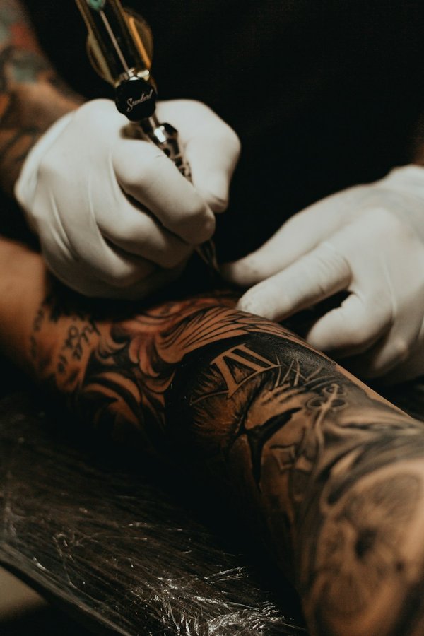 Professional tattoo artist using rotary machine in a clean studio session